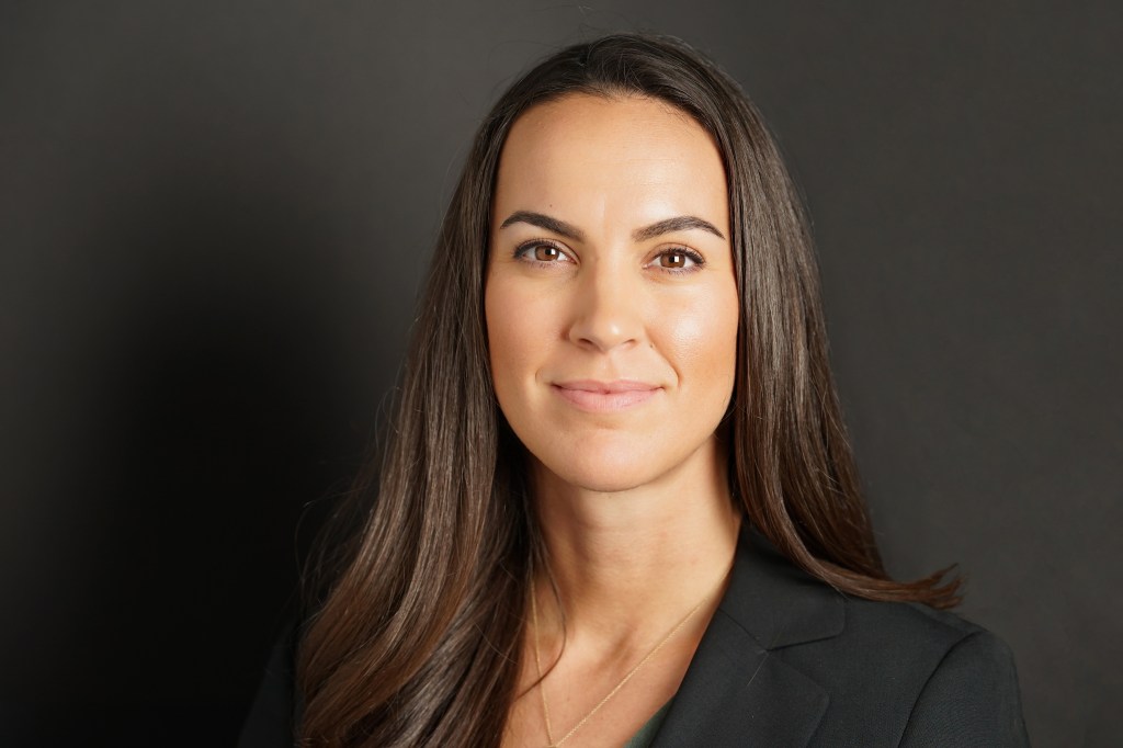 Professional headshot of brunette woman with brown eyes and tan skin wearing a black blazer who is an interior designer in Phoenix Arizona